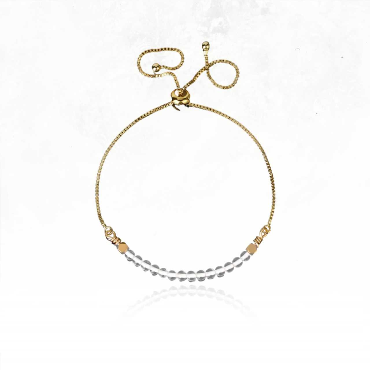 Bijou doré minimaliste avec perles de pierre naturelle de quartz clair.