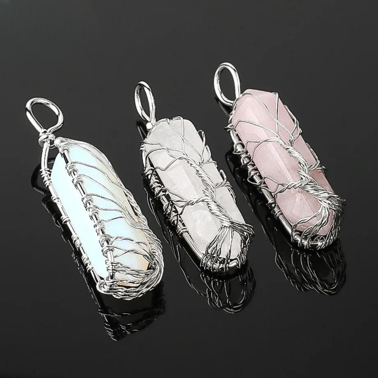 Pendentif artisanal en pierre brute enveloppĂ© dâun arbre en fil de cuivre.