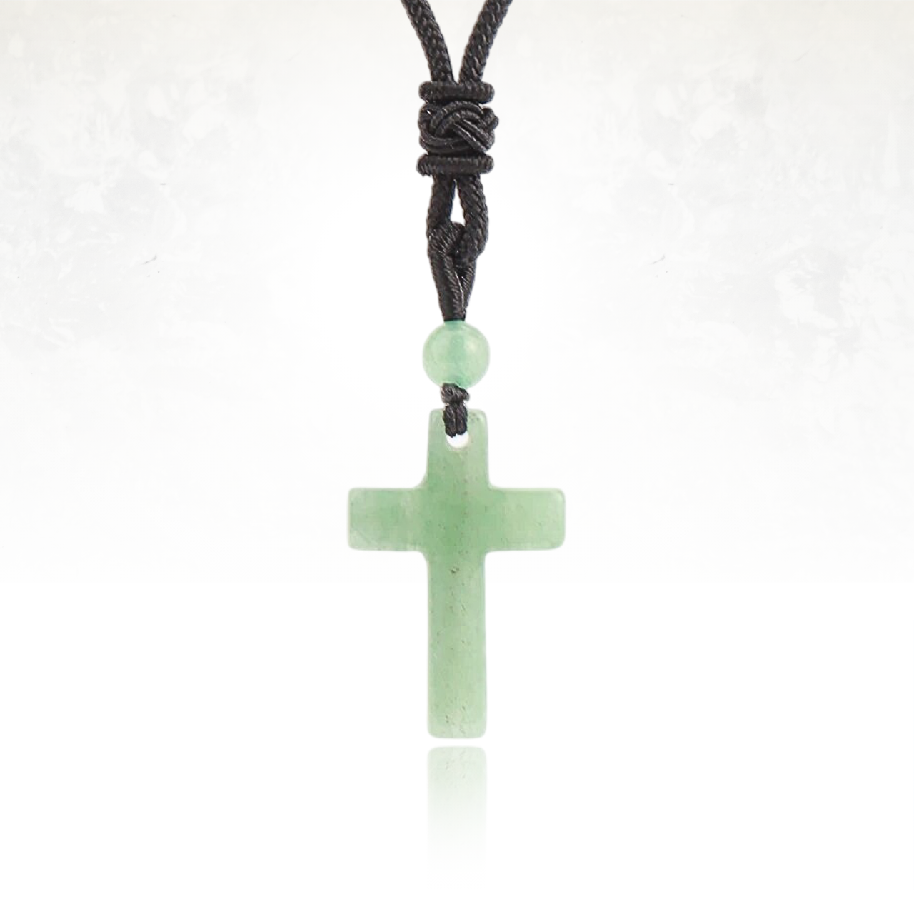 Croix en AVENTURINE montée sur un cordon noir ajustable.