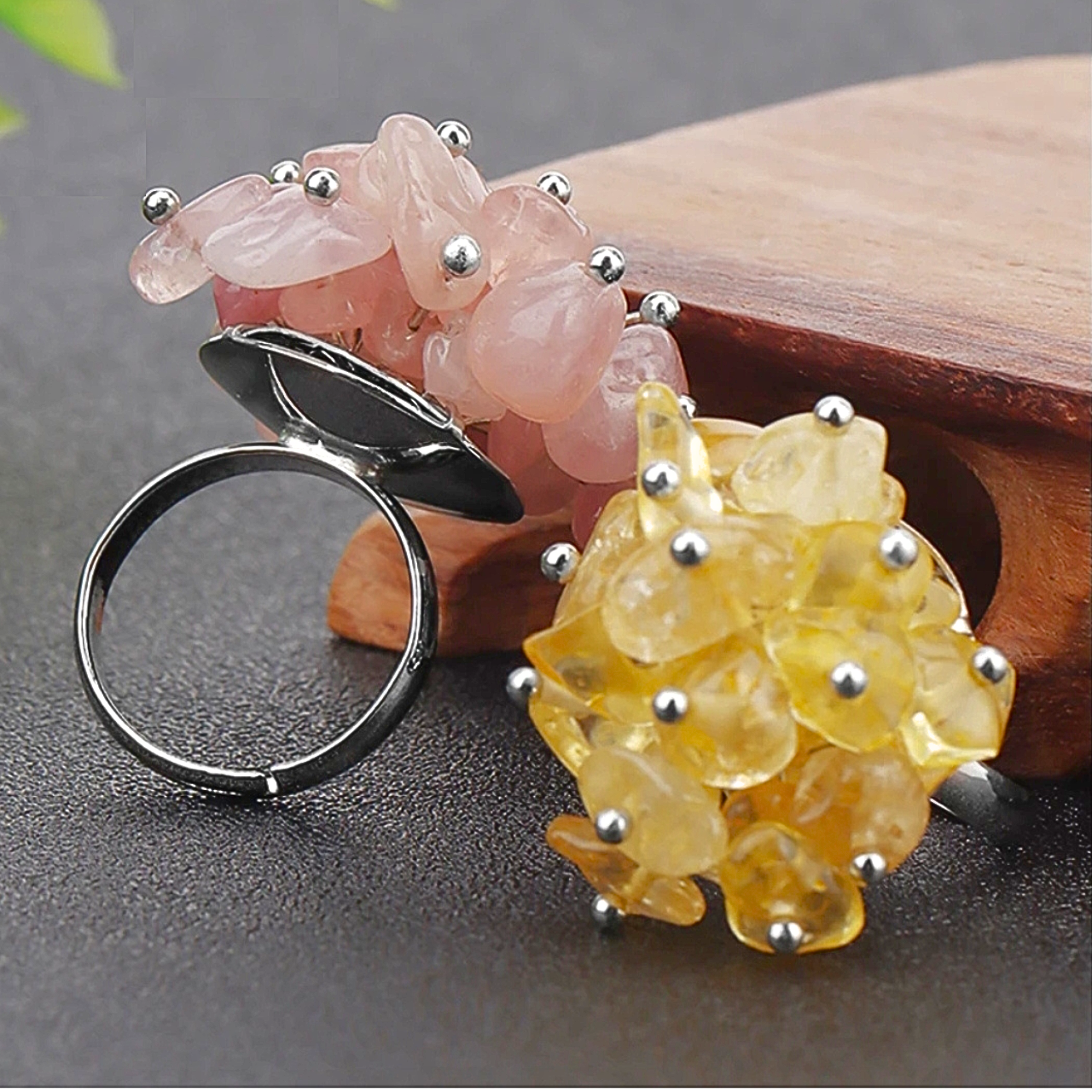 Création originale avec pierres irrégulières jaunes et rose fixées par des clous métalliques.