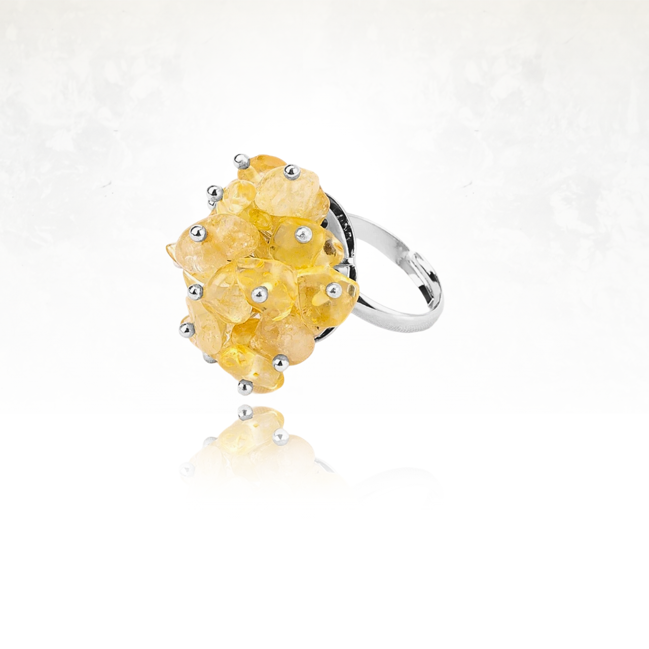 Bague fantaisie ornée de pierres jaunes citrine polies sur monture argentée.