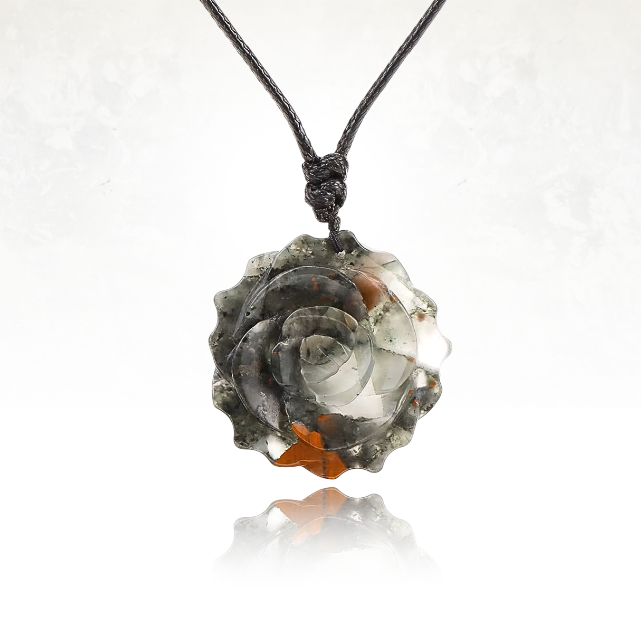 Pendentif rose sculpté, suspendu à une corde noire élégante.