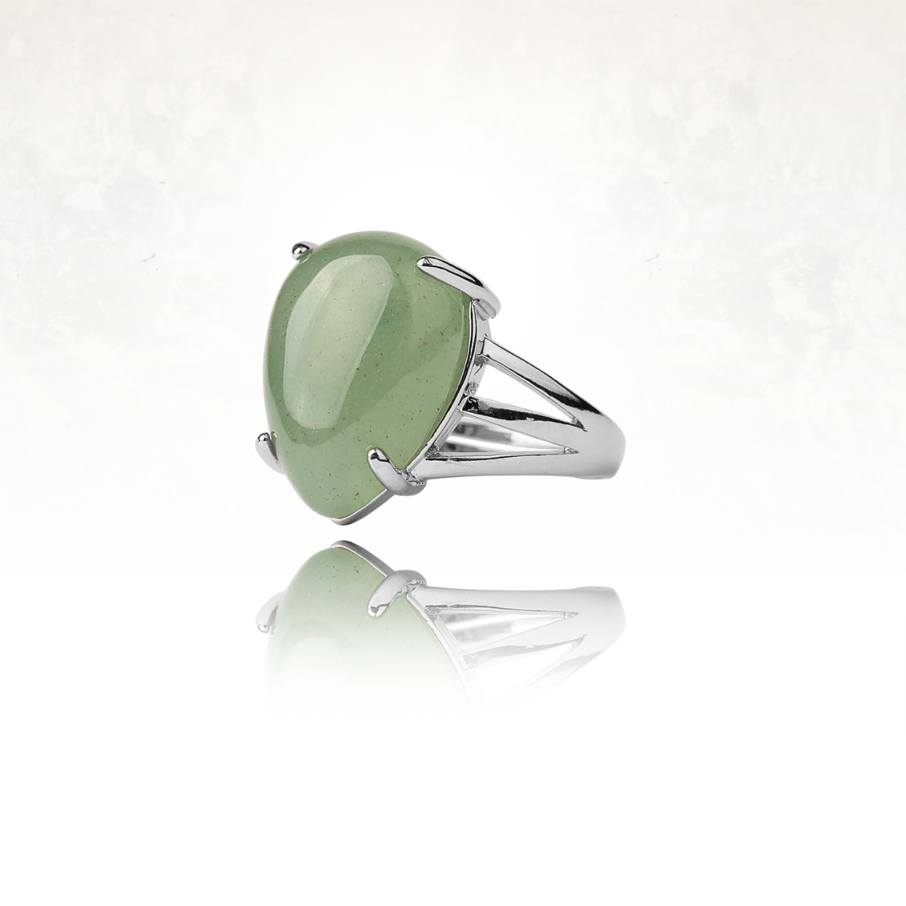 Bague en métal brillant avec une grande pierre verte ovale.