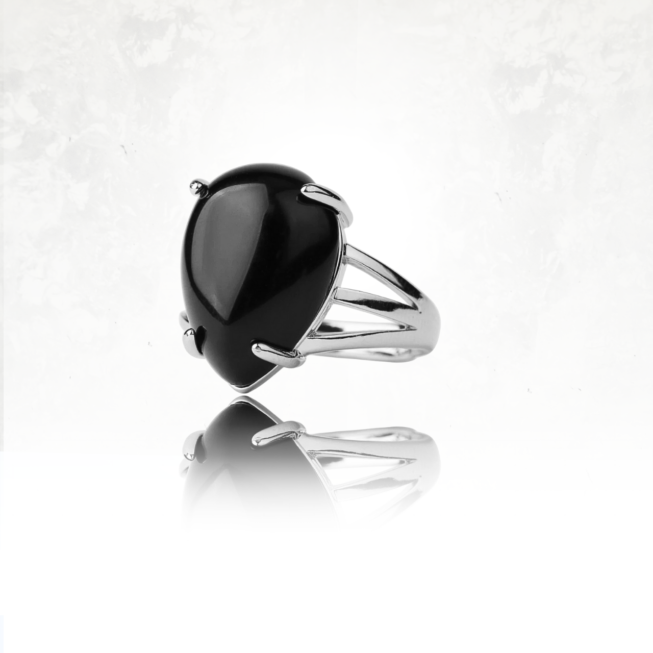 Bague avec obsidienne
en forme de goutte, monture argentée ouverte.