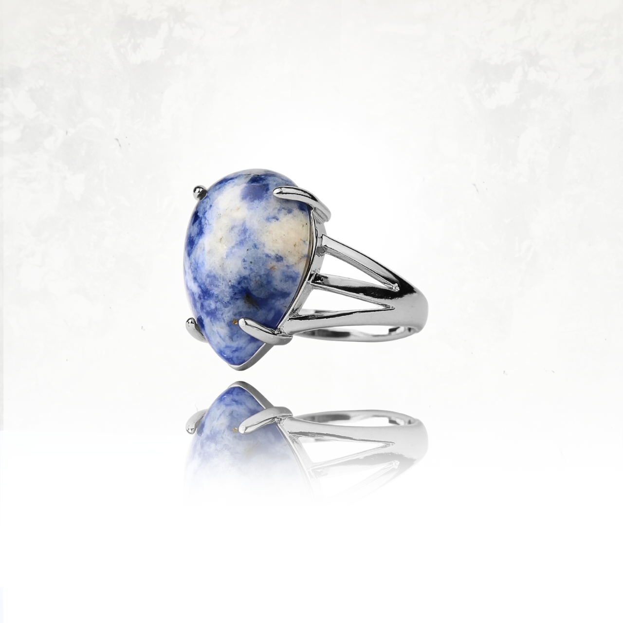 ĂlĂ©gante bague avec pierre naturelle bleue et blanche montĂ©e sur un anneau en mĂ©tal argentĂ©.