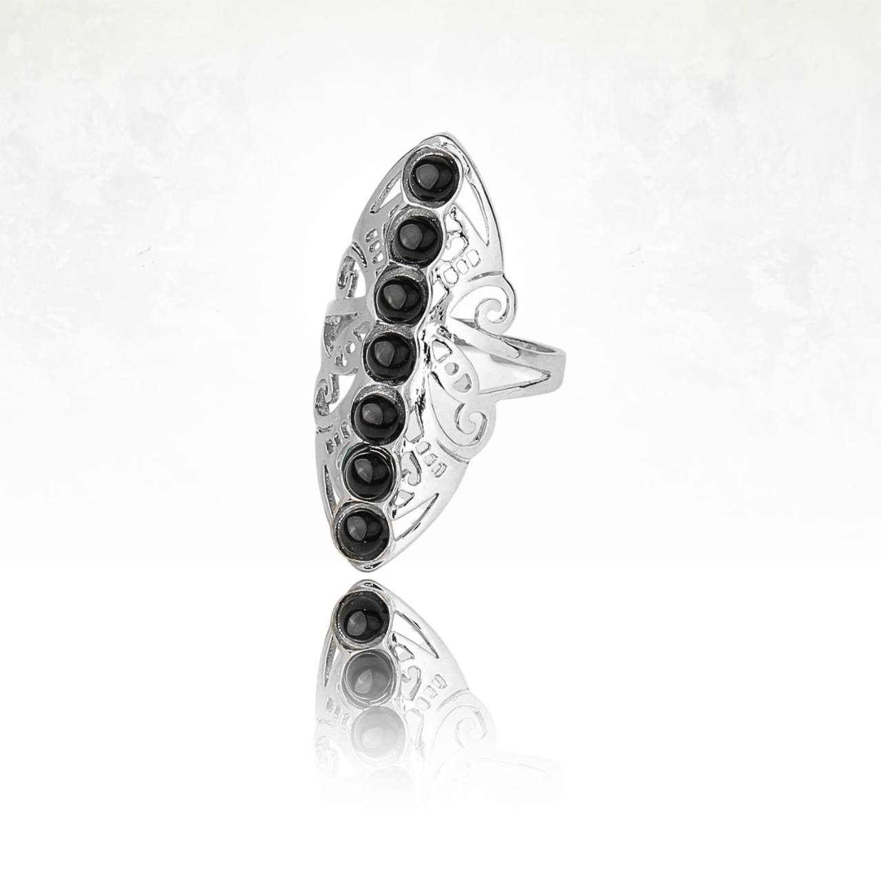 Anneau fantaisie argenté avec alignement de pierres noires brillantes.