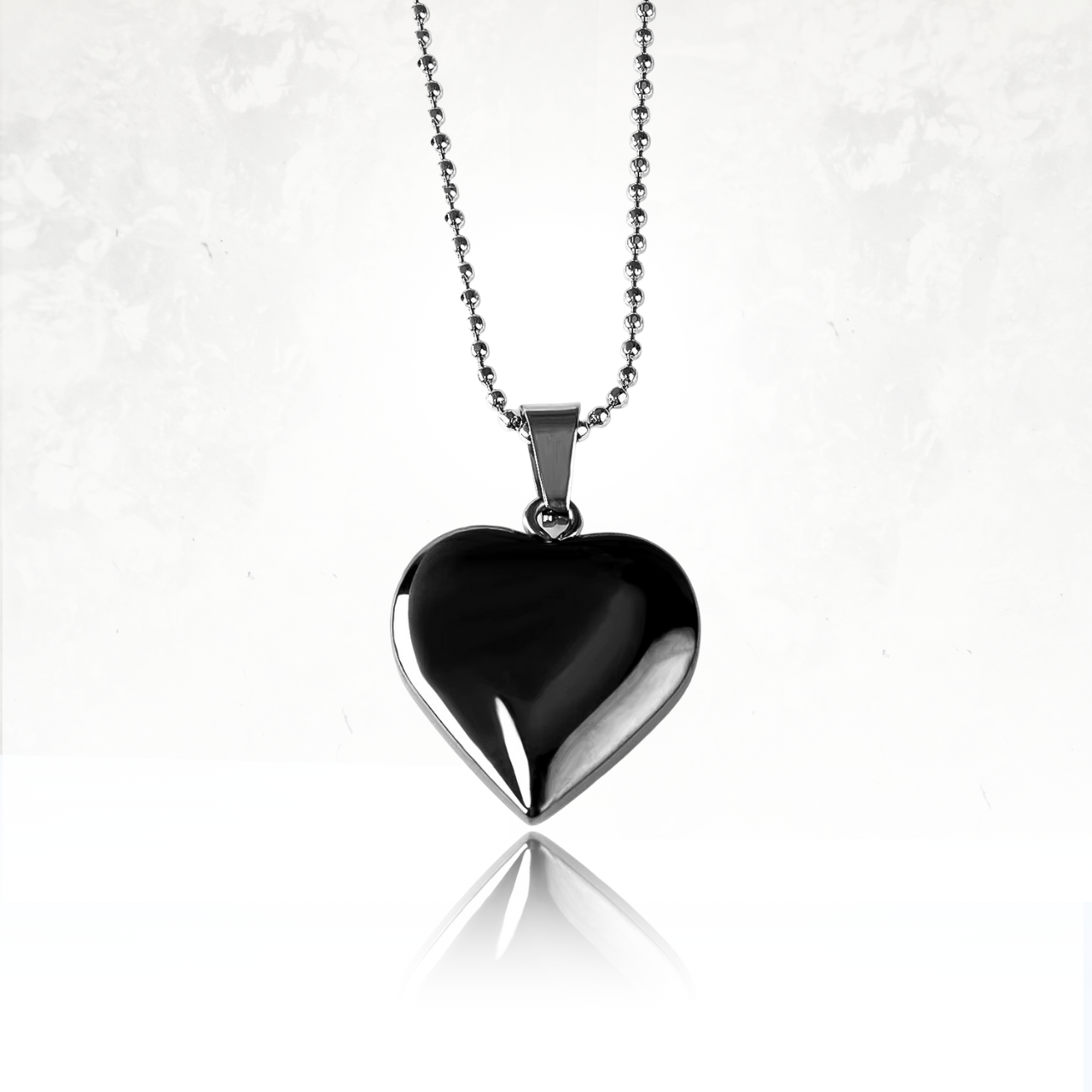 Pendentif cœur en agate noire suspendu à une chaîne en acier.