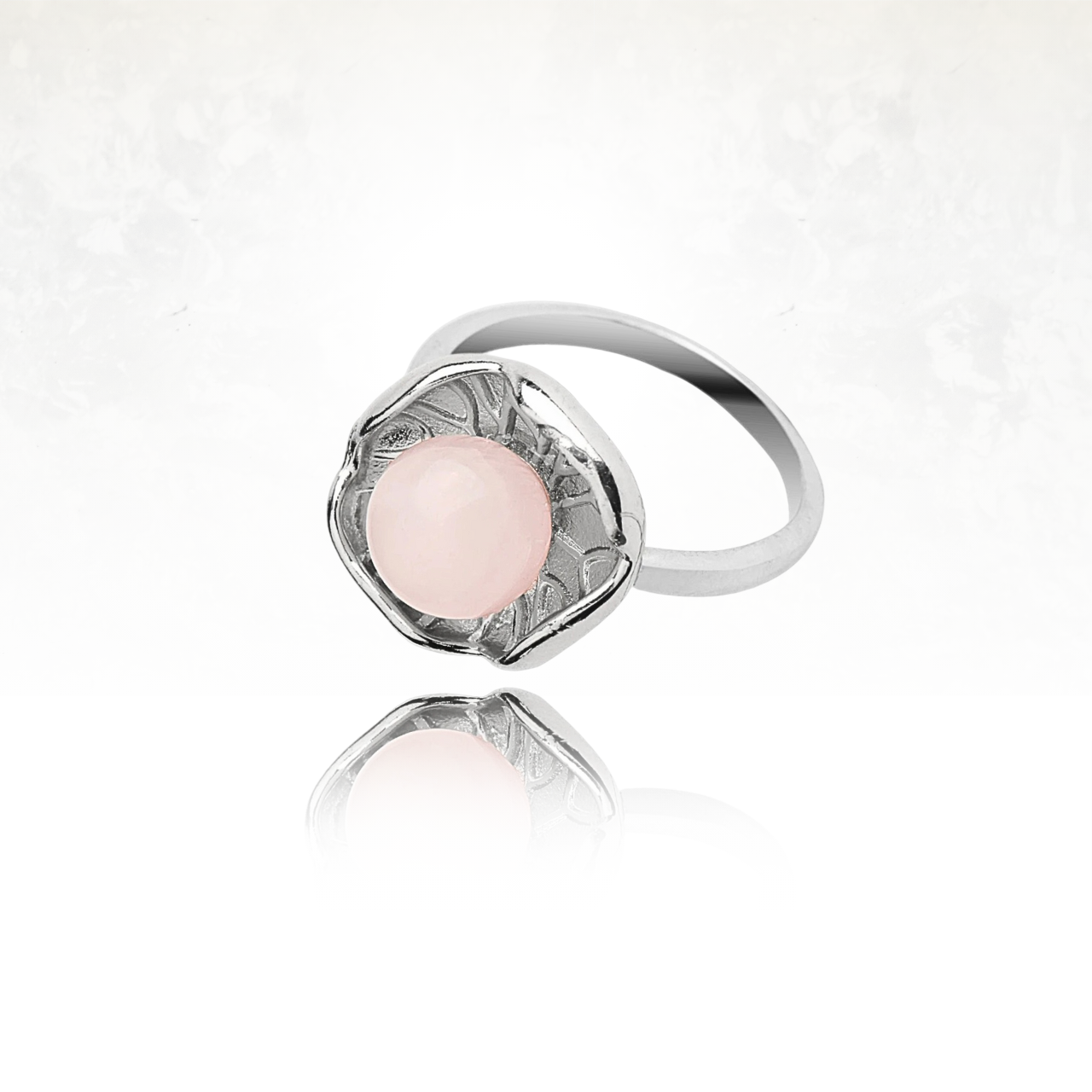 Anneau ajustable en métal argenté avec motif lotus et pierre bleue rose translucide.