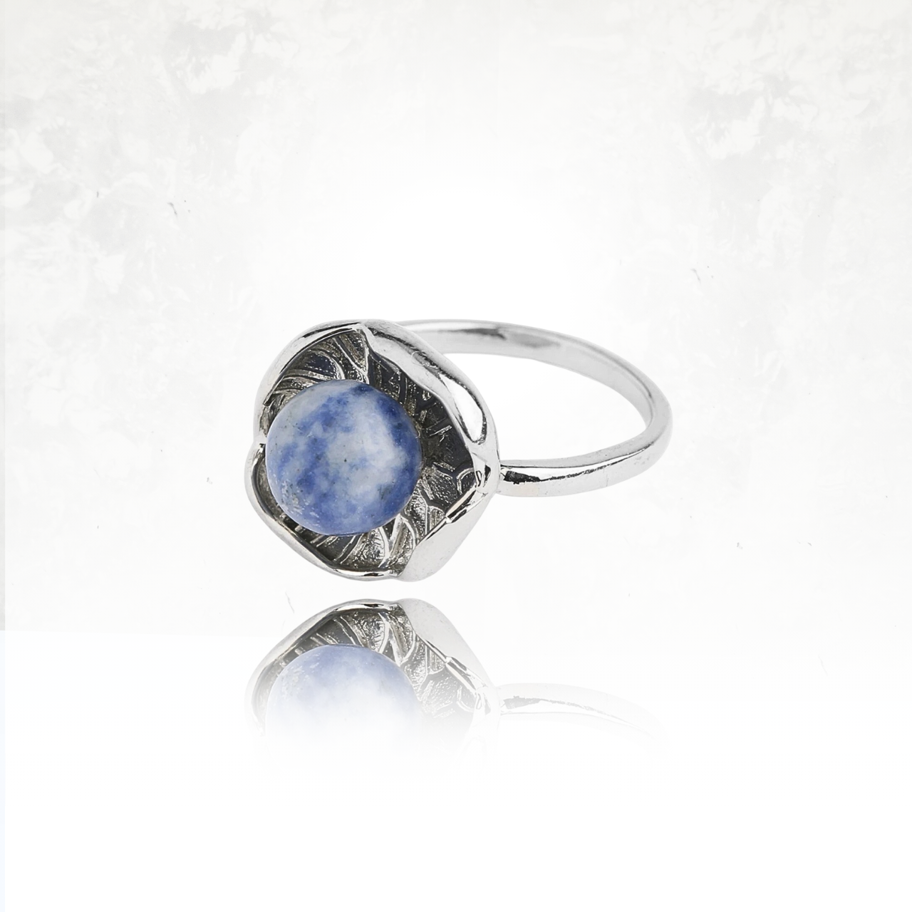 Bague au design floral représentant un lotus avec une pierre bleue et blanche.