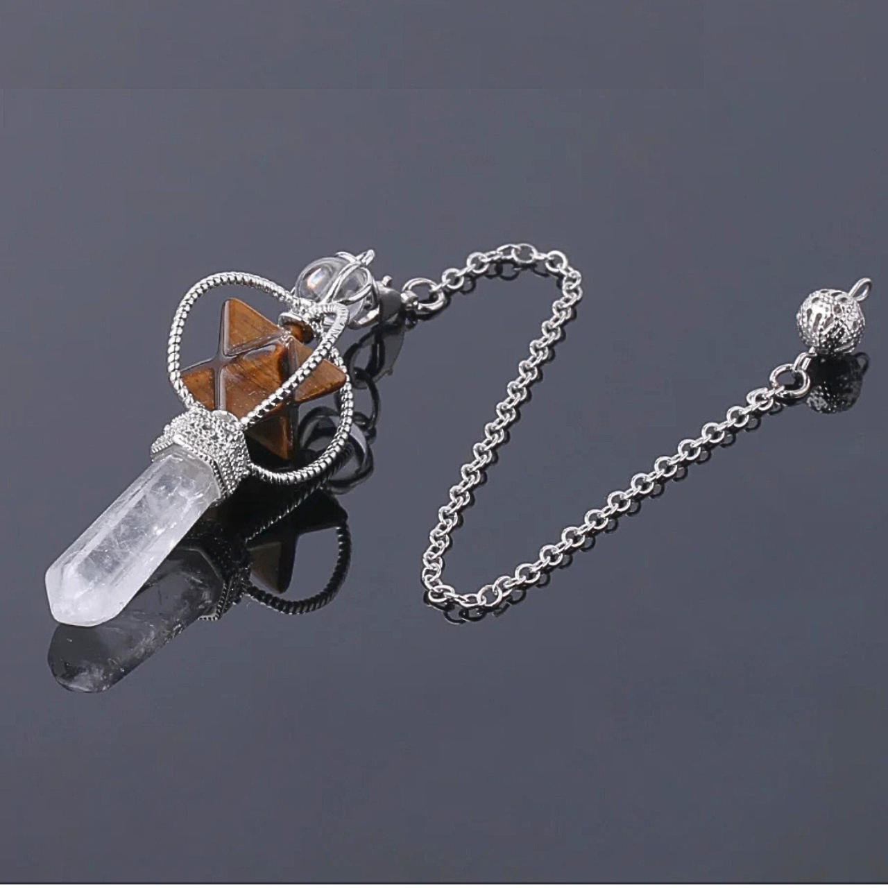 Pendule SINYA avec Merkaba en pierre naturelle marron dorée et pointe en quartz clair, monté sur chaîne argentée.