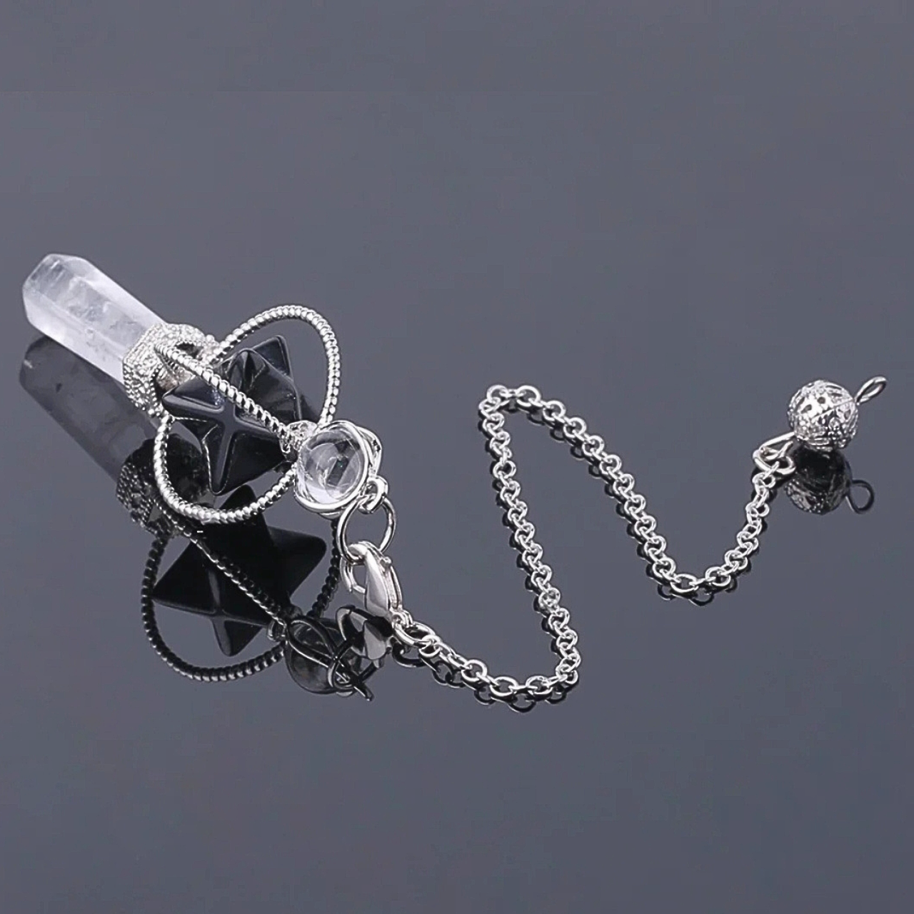 Bijou énergétique SINYA représentant une Merkaba sculptée dans de la pierre naturelle et surmontant une pointe de quartz clair.