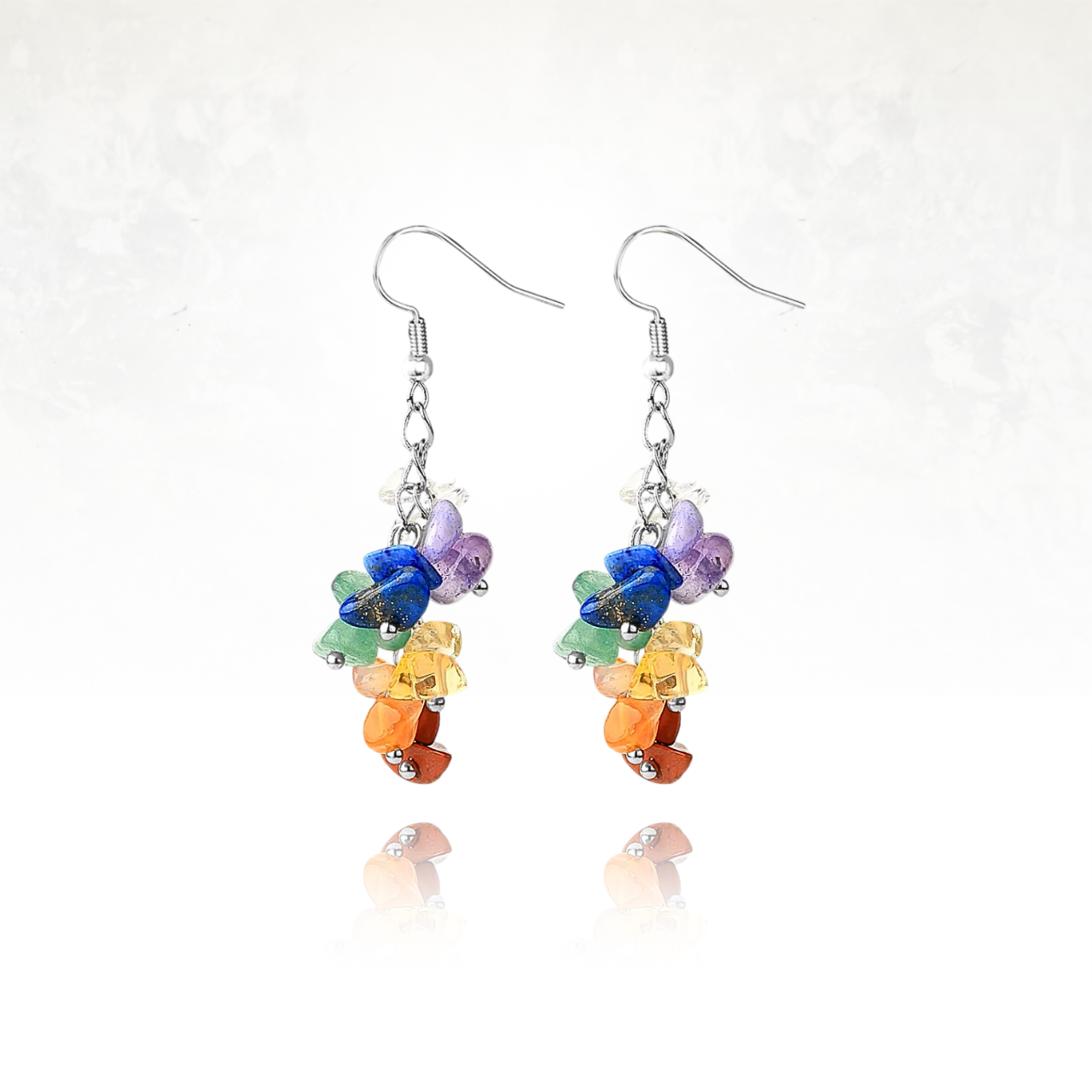 Boucles d'oreilles artisanales ornées de différentes pierres naturelles représentant les couleurs des 7 chakras.