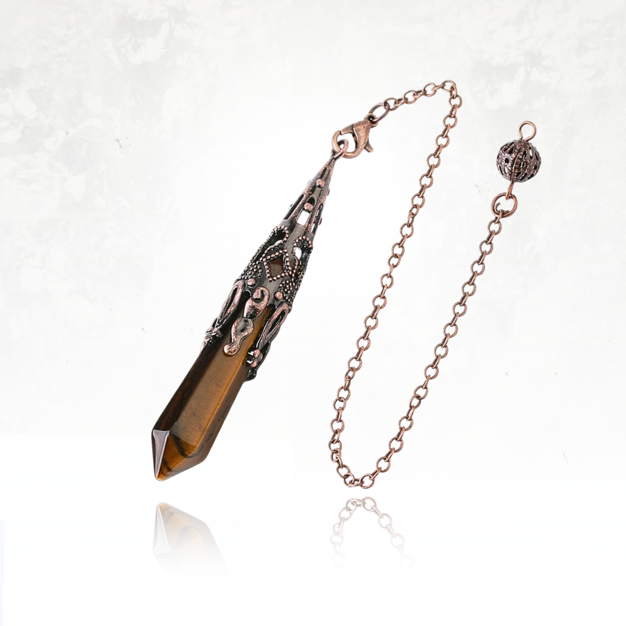Accessoire d'énergie spirituelle avec pendule en pointe et métal orné.