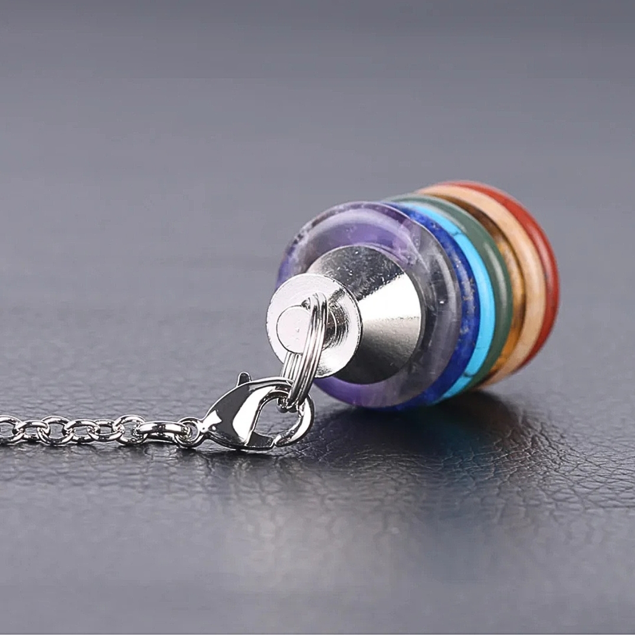 Instrument de radiesthésie avec superposition de pierres des chakras, conçu pour la détection et l’équilibrage des énergies.