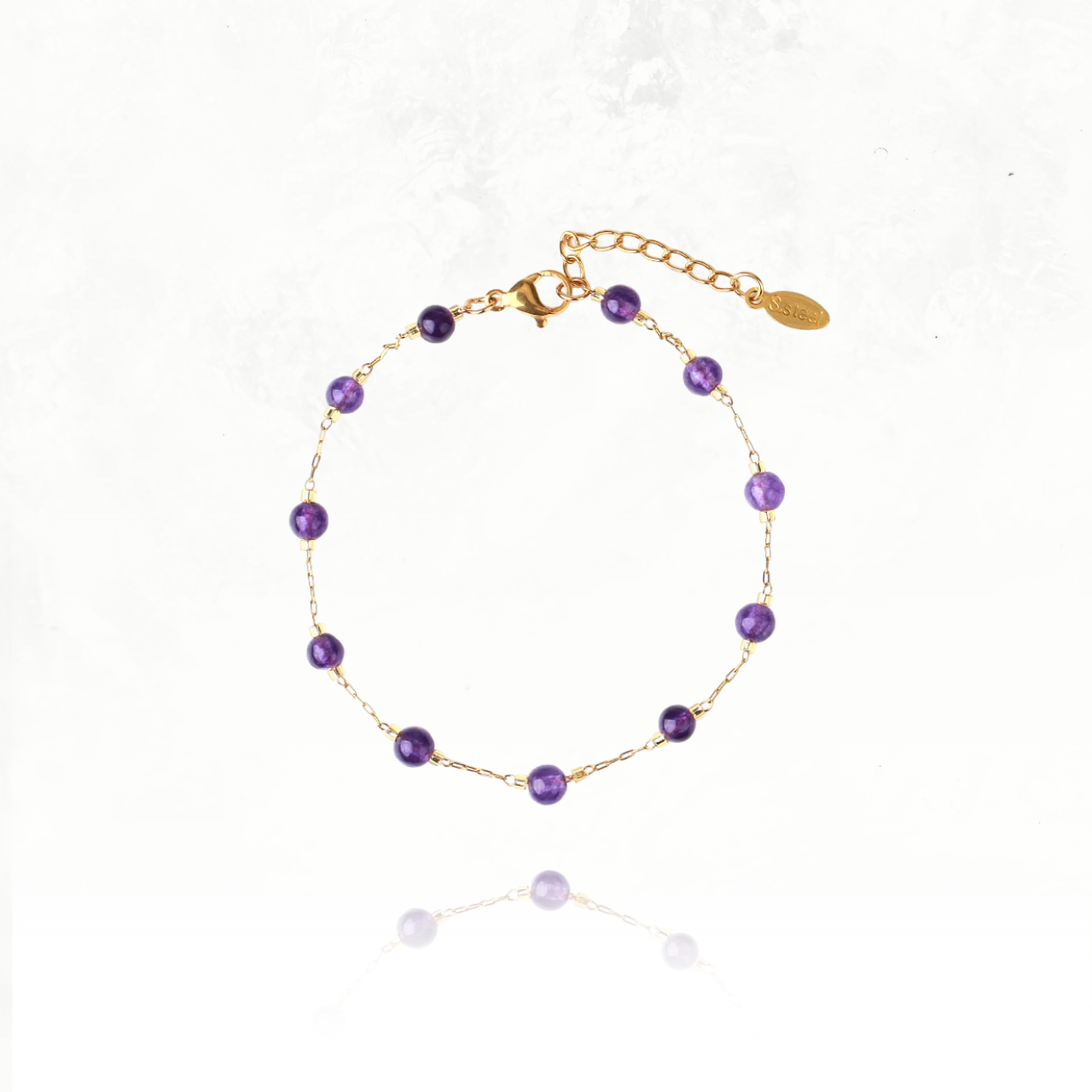 Bracelets fins dorés avec gemmes naturelles, symboles de protection et d’harmonie.