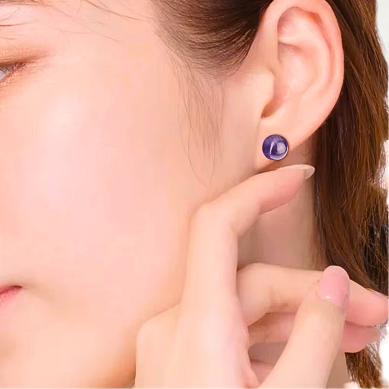 Boucle d'oreille ronde en améthyste portée par une femme