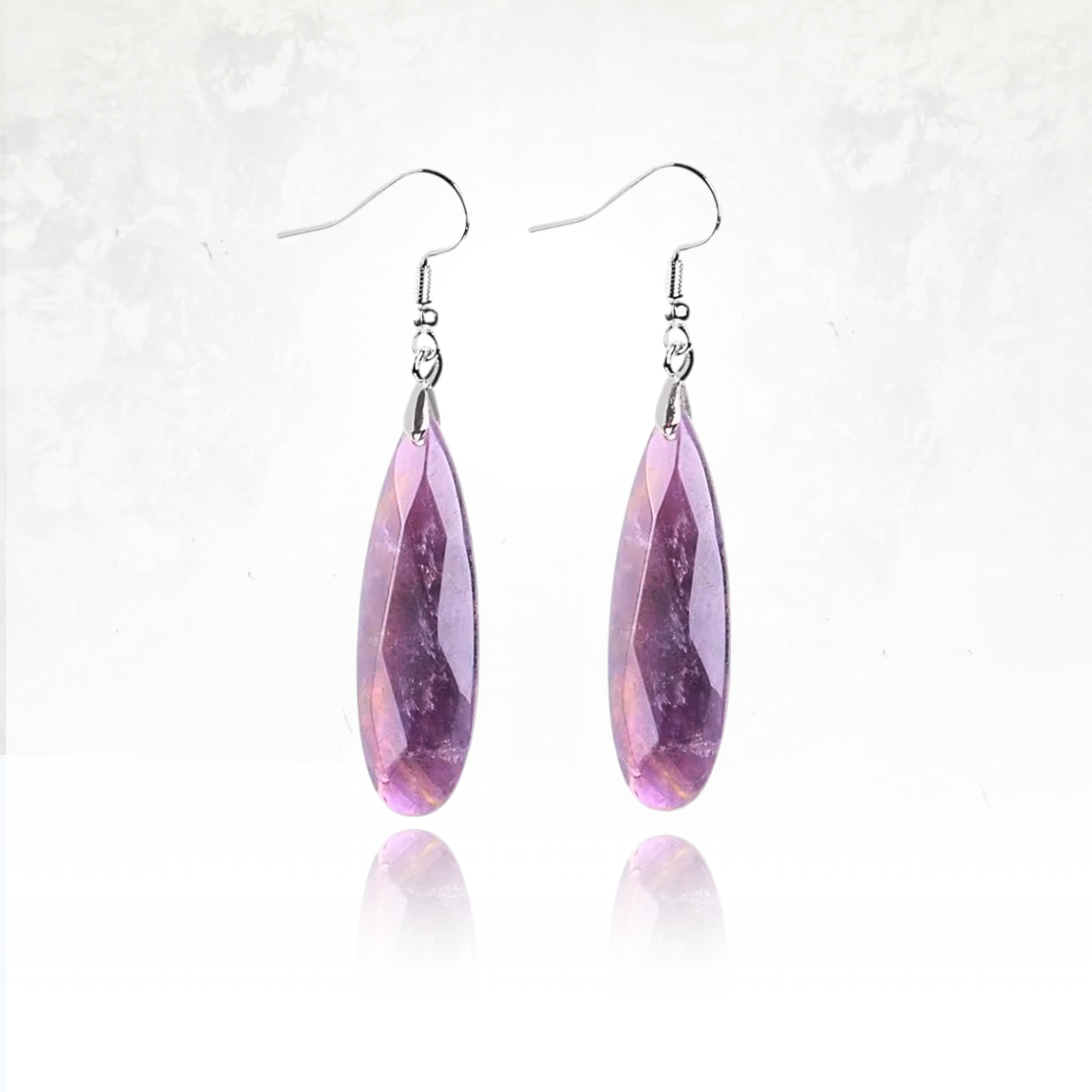 Boucles d'oreilles SHANTI en améthyste avec reflets lumineux.
