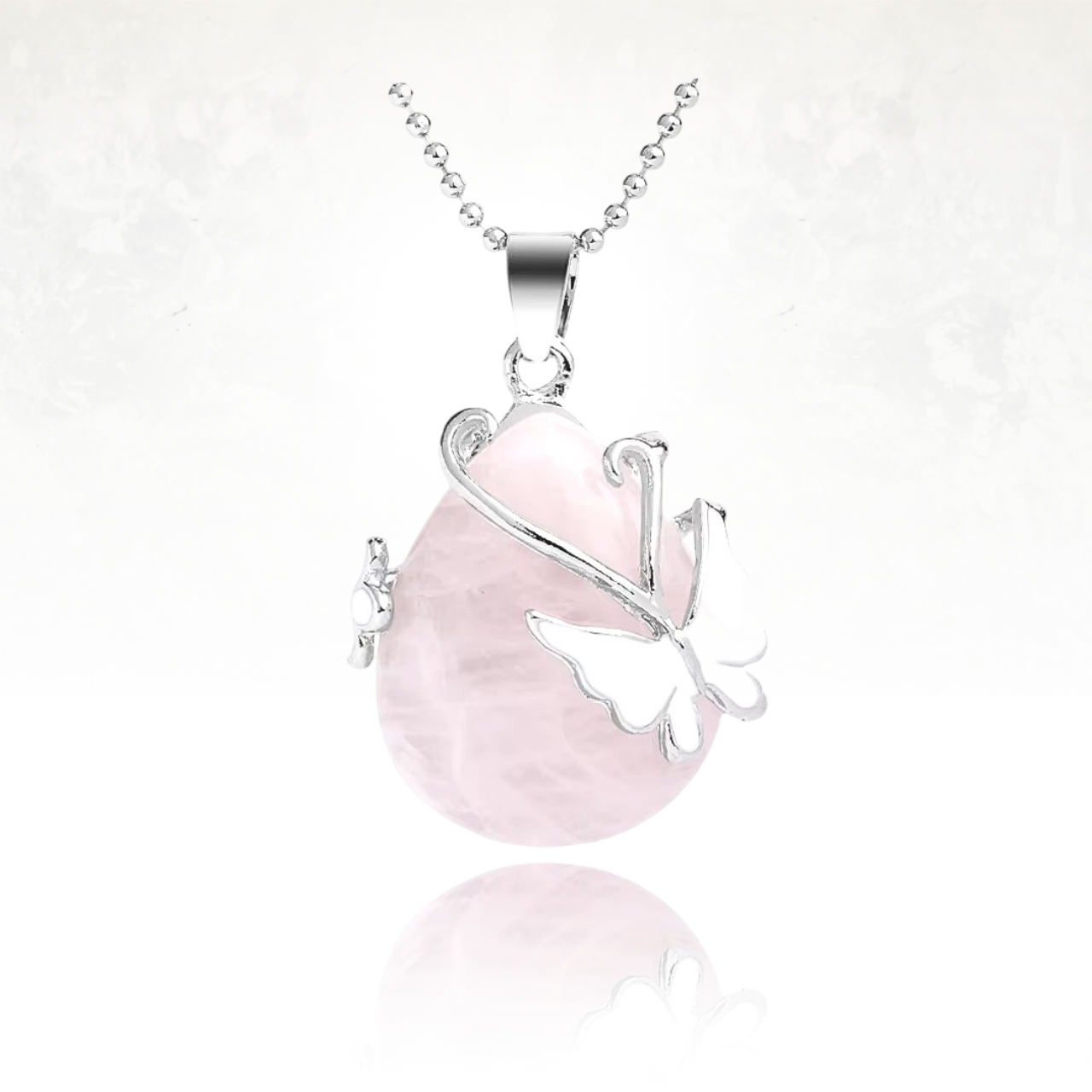 Élégant collier en pierre naturelle de quartz rose orné d’un papillon délicat en métal blanc.