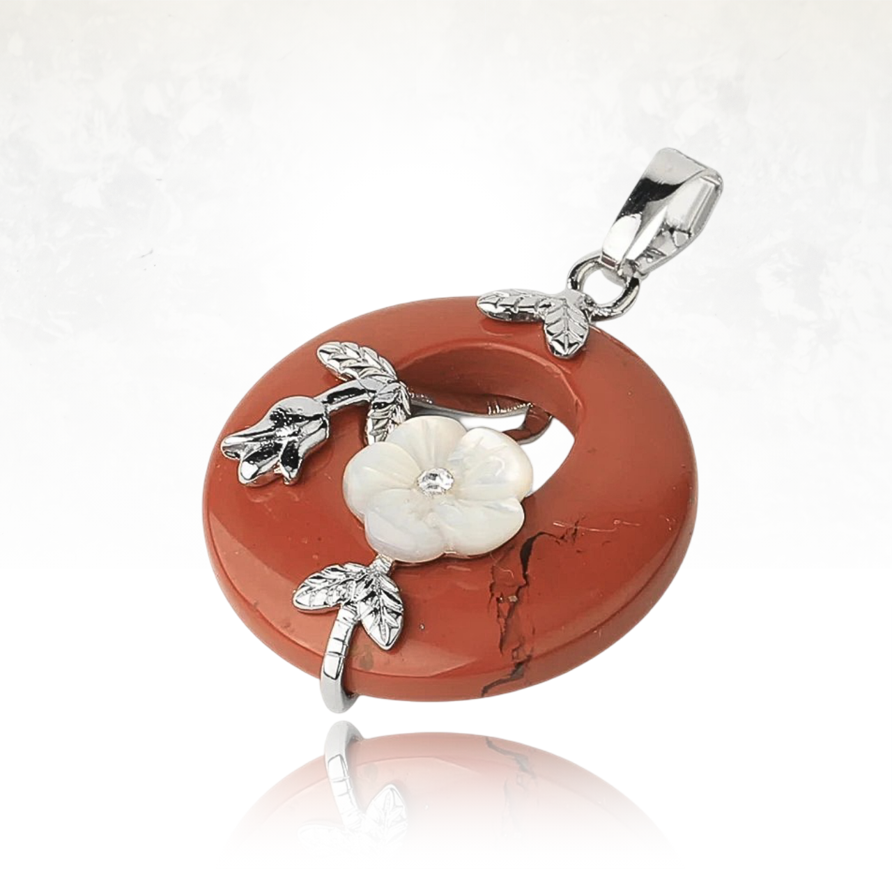 Bijou en jaspe rouge avec une fleur blanche délicate et des branches argentées.