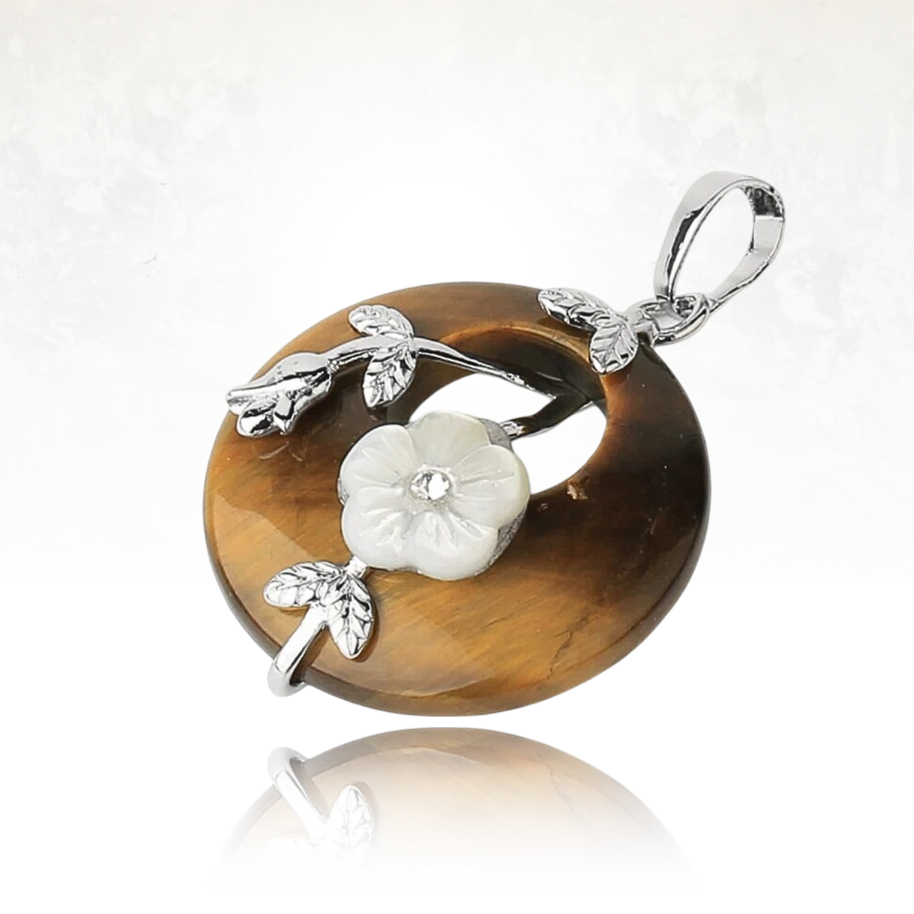 Pendentif circulaire en pierre naturelle avec une fleur en nacre et feuilles argentées.
