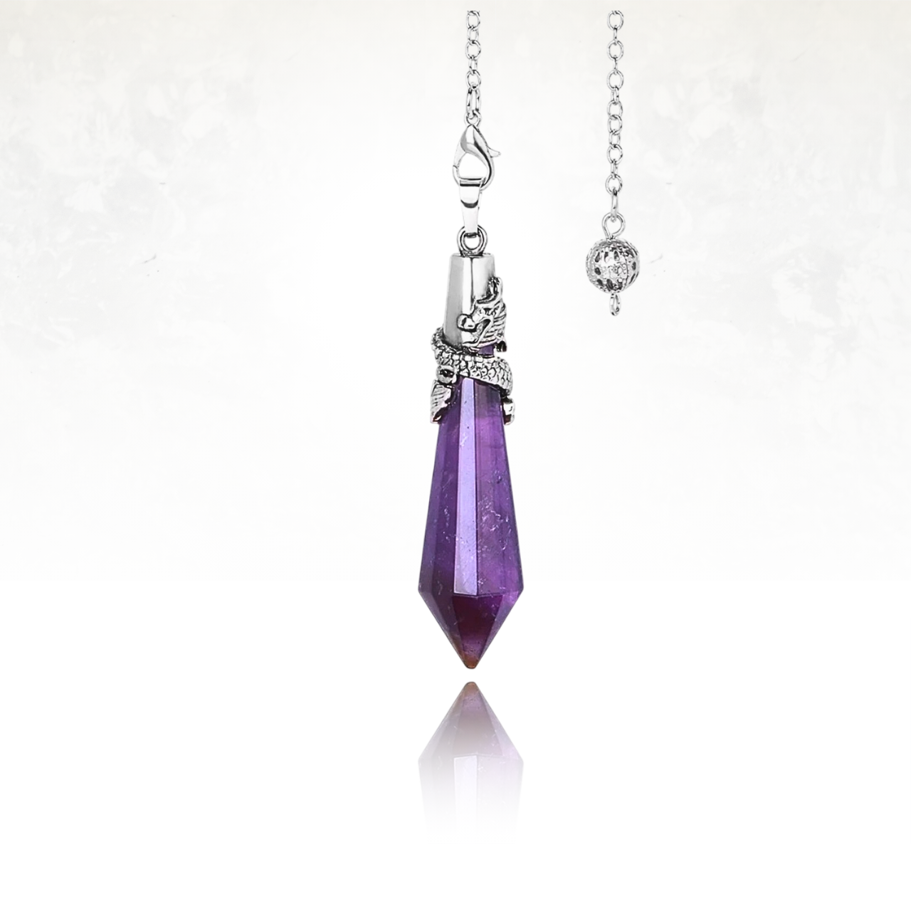 Élégant pendule en améthyste taillée avec un motif dragon en métal.

