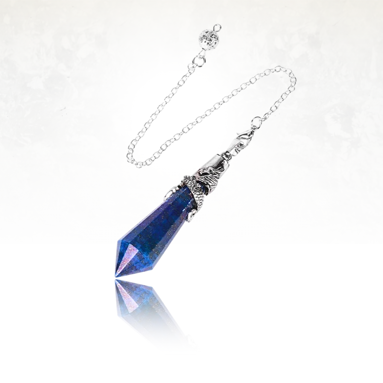Magnifique pendule en lapis lazuli avec une monture argentée et un dragon en relief.

