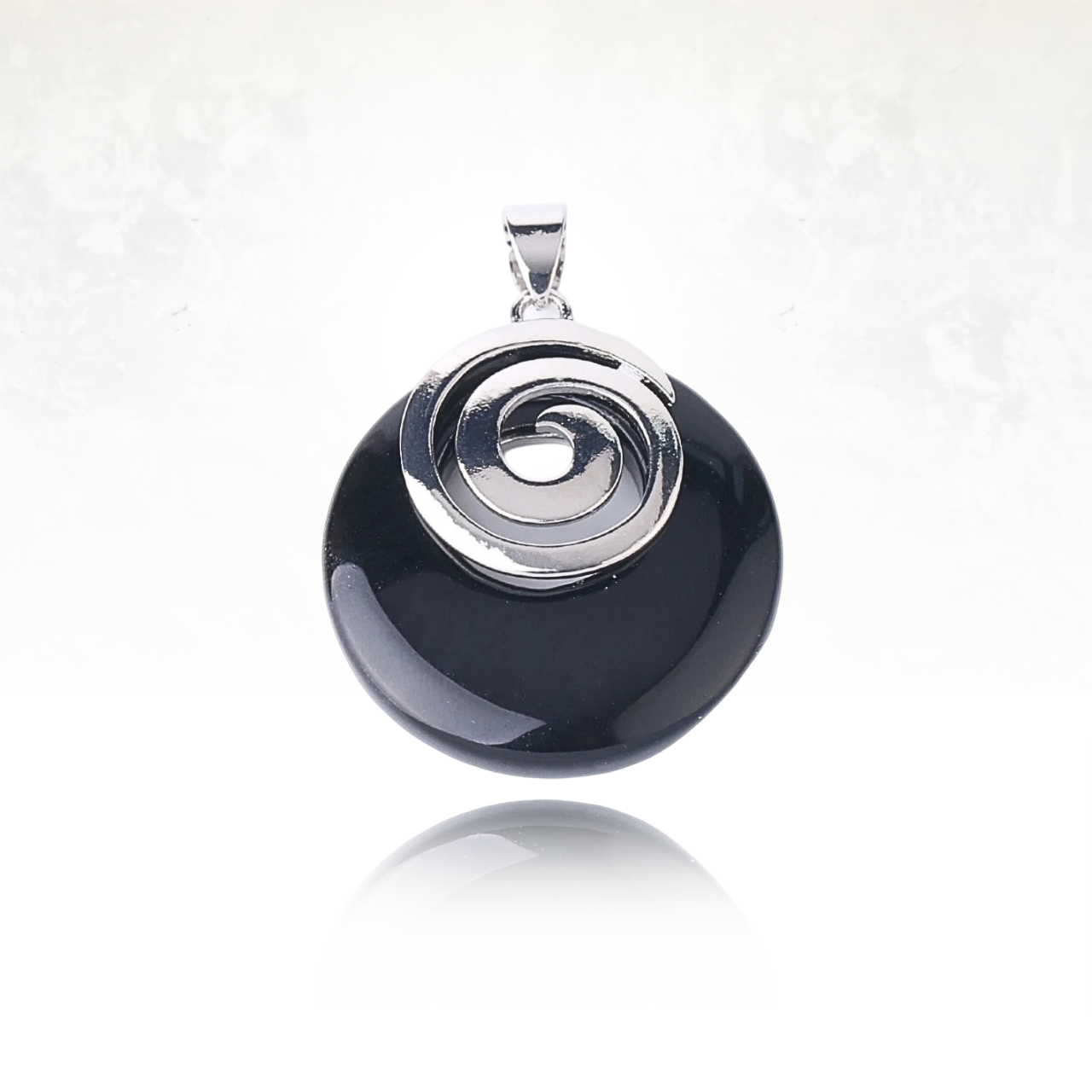 Pierre noire polie ornée d’une spirale argentée brillante

