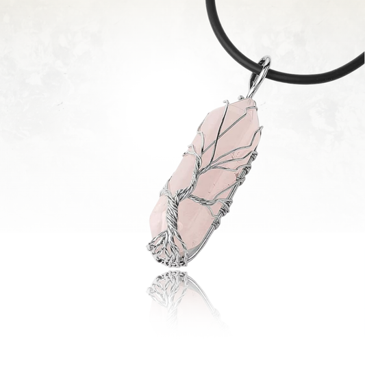 Pendentif en quartz rose entouré d’un fil en cuivre formant un arbre symbolique.