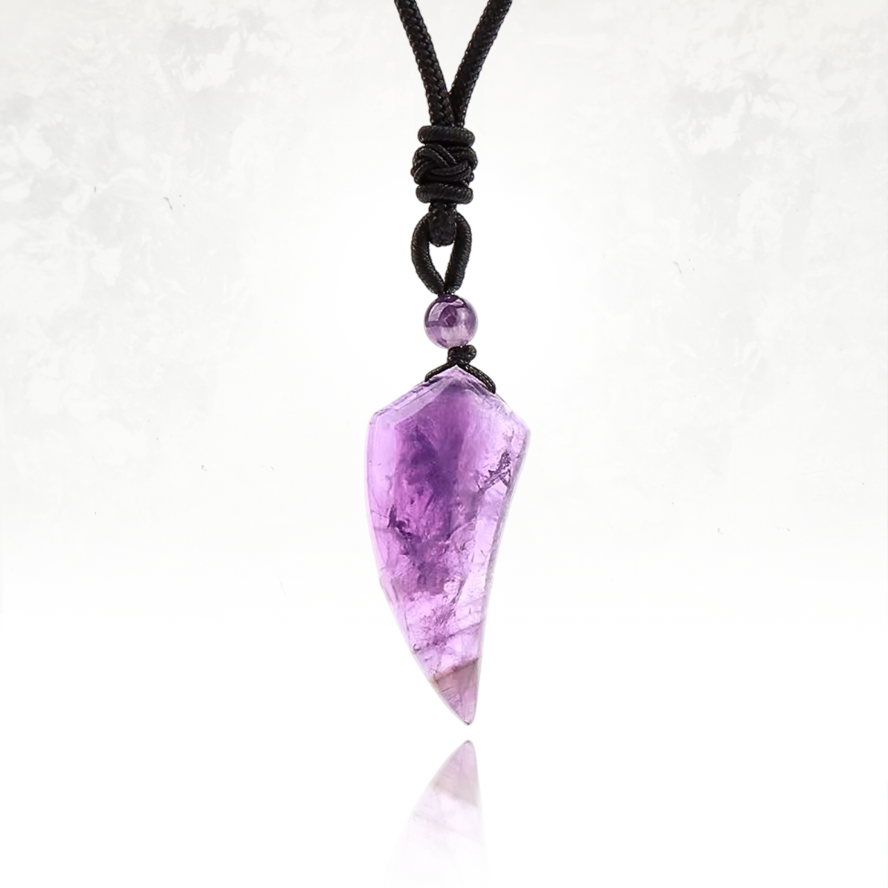 Amulette en dent de loup sculptée dans de l'amethyste pour force et courage.

