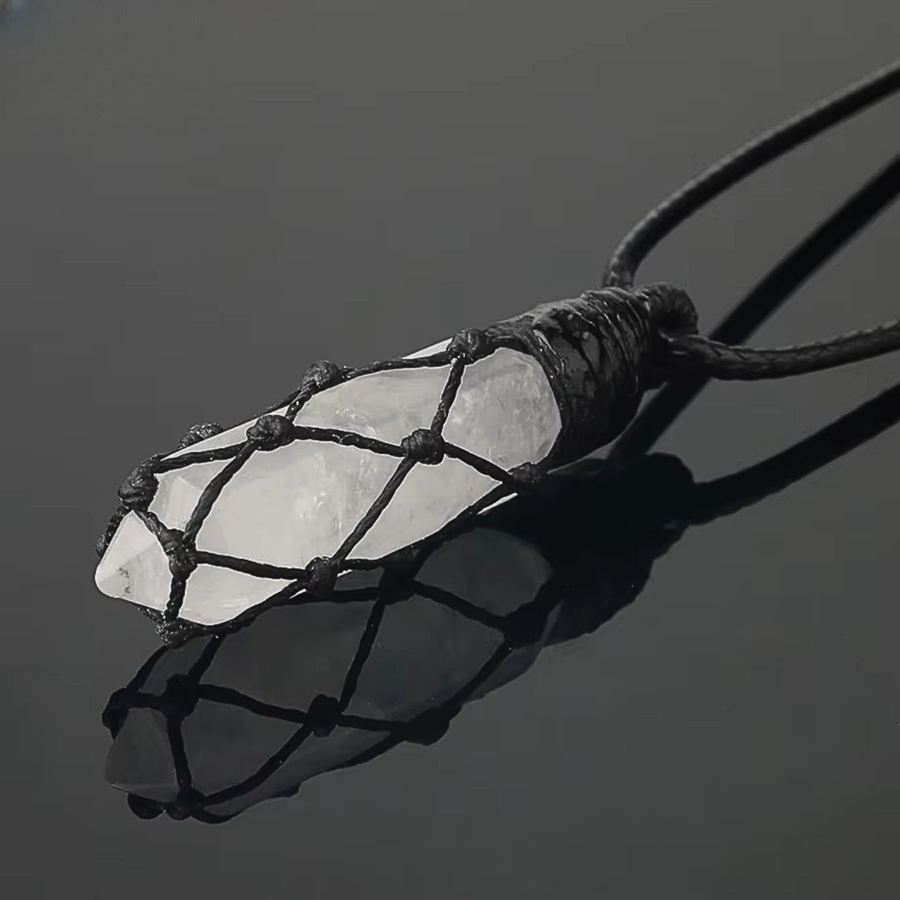 Bijou hippie avec pierre semi-précieuse de quartz clair brute entourée d’un tressage noir.

