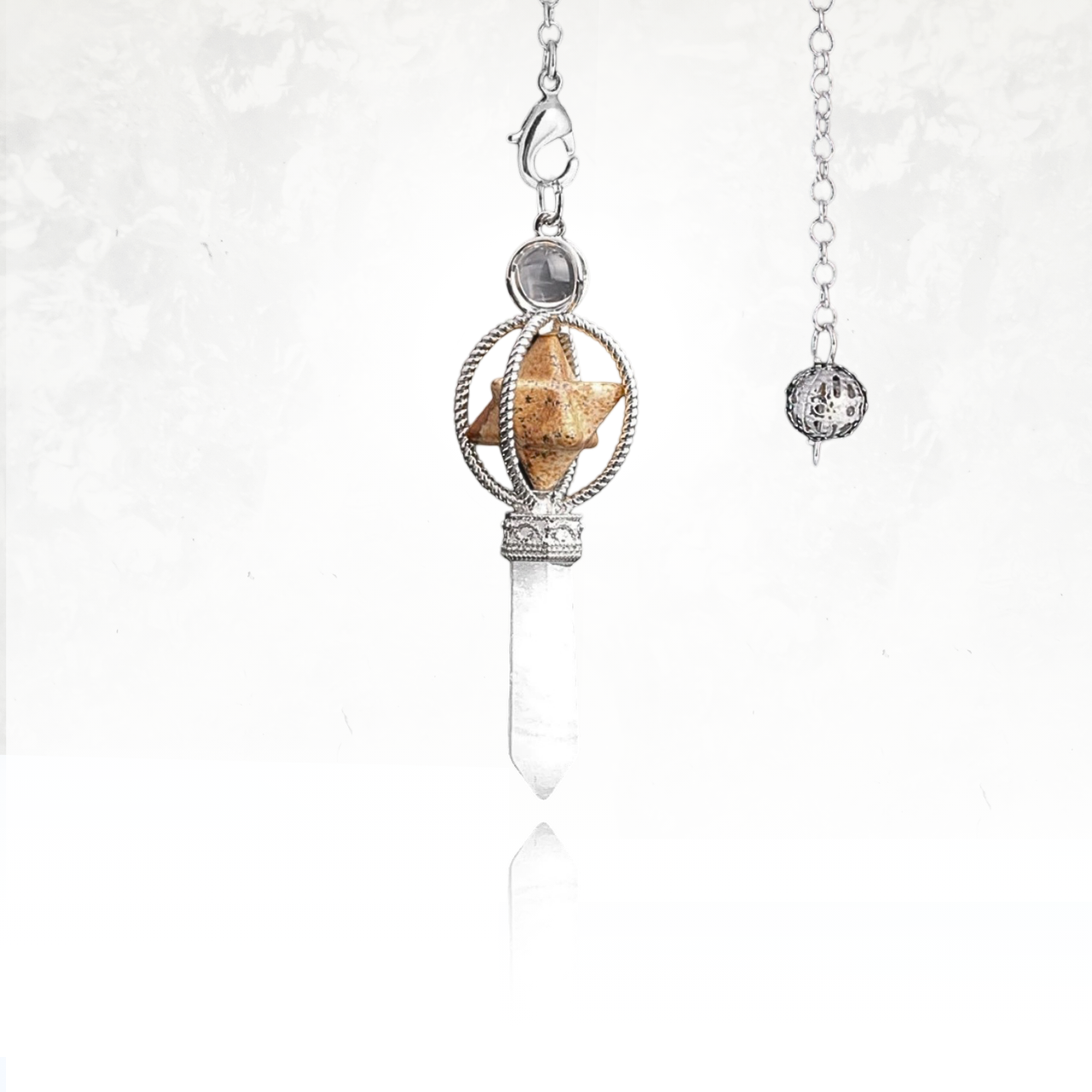 Accessoire de méditation SINYA avec structure Merkaba et cristal de quartz clair suspendu à une chaîne.