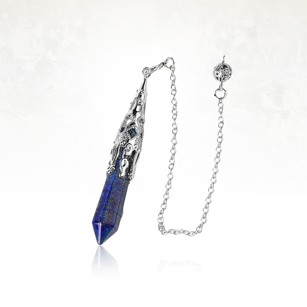 Outil mystique en métal gravé et cristal allongé.