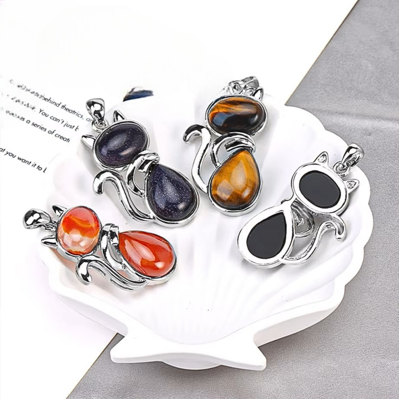 Pendentif chat stylisé en pierre naturelle aux reflets divers.

