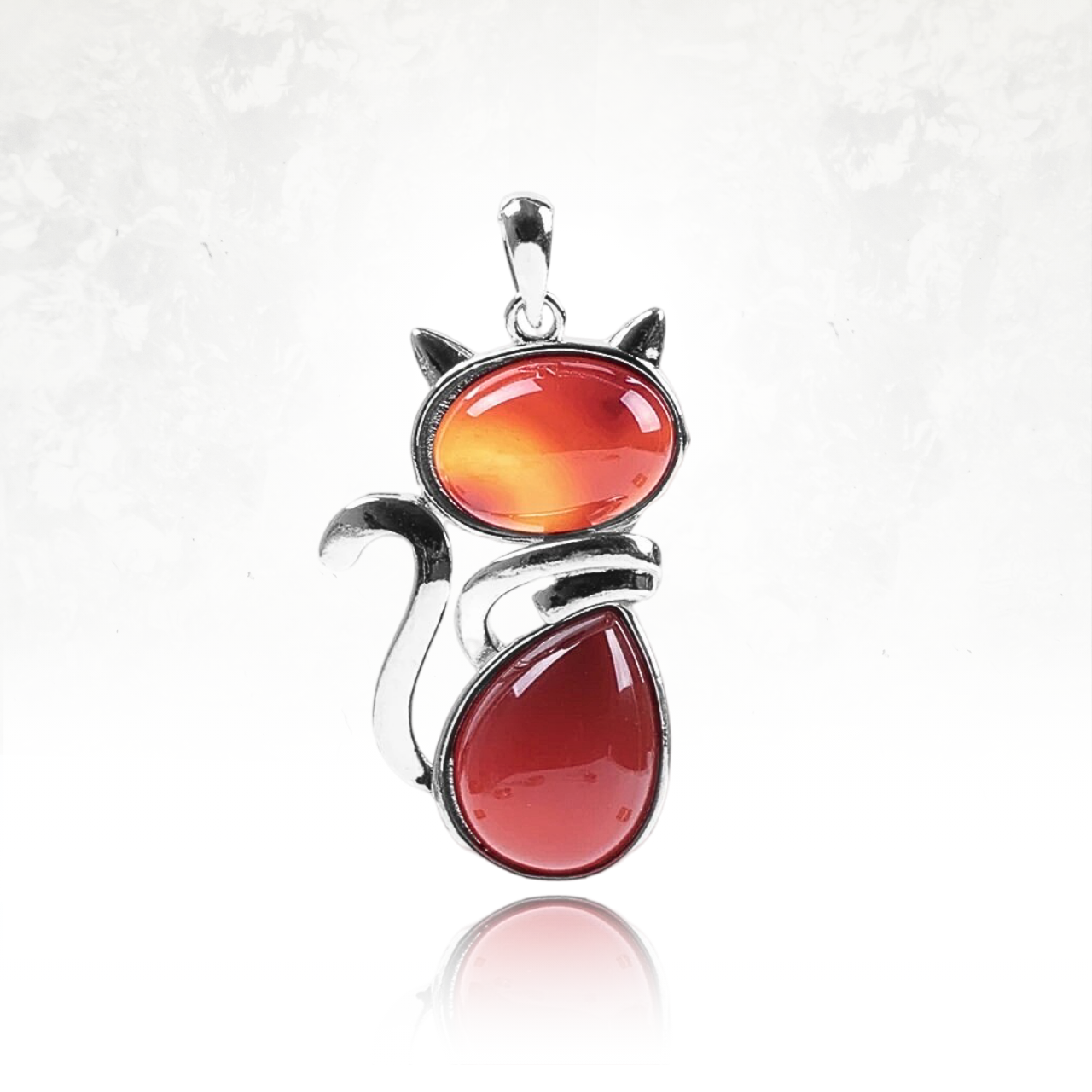 Accessoire unique avec un chat serti de pierres naturelles rouges.

