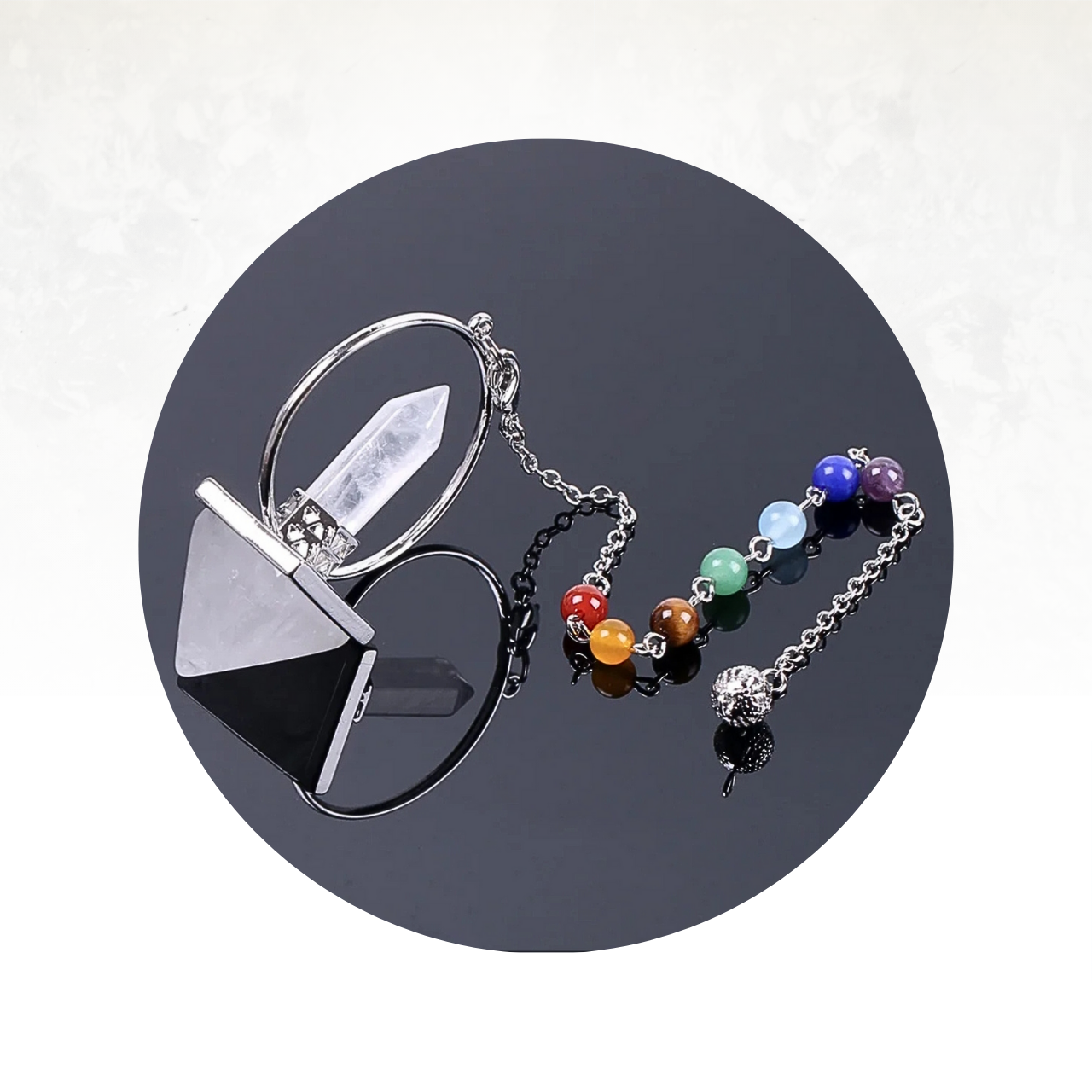 Pendule divinatoire en quartz clair et perles multicolores, utilisé pour l’interprétation des énergies subtiles et la méditation.