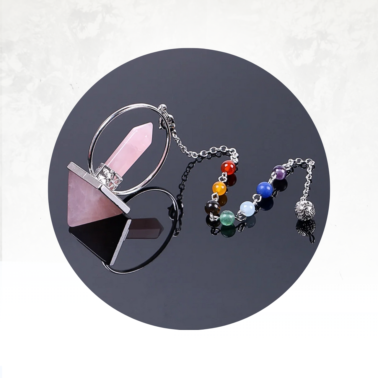 Outil divinatoire au design unique, combinant une pointe de quartz rose et un anneau métallique pour amplifier les vibrations.