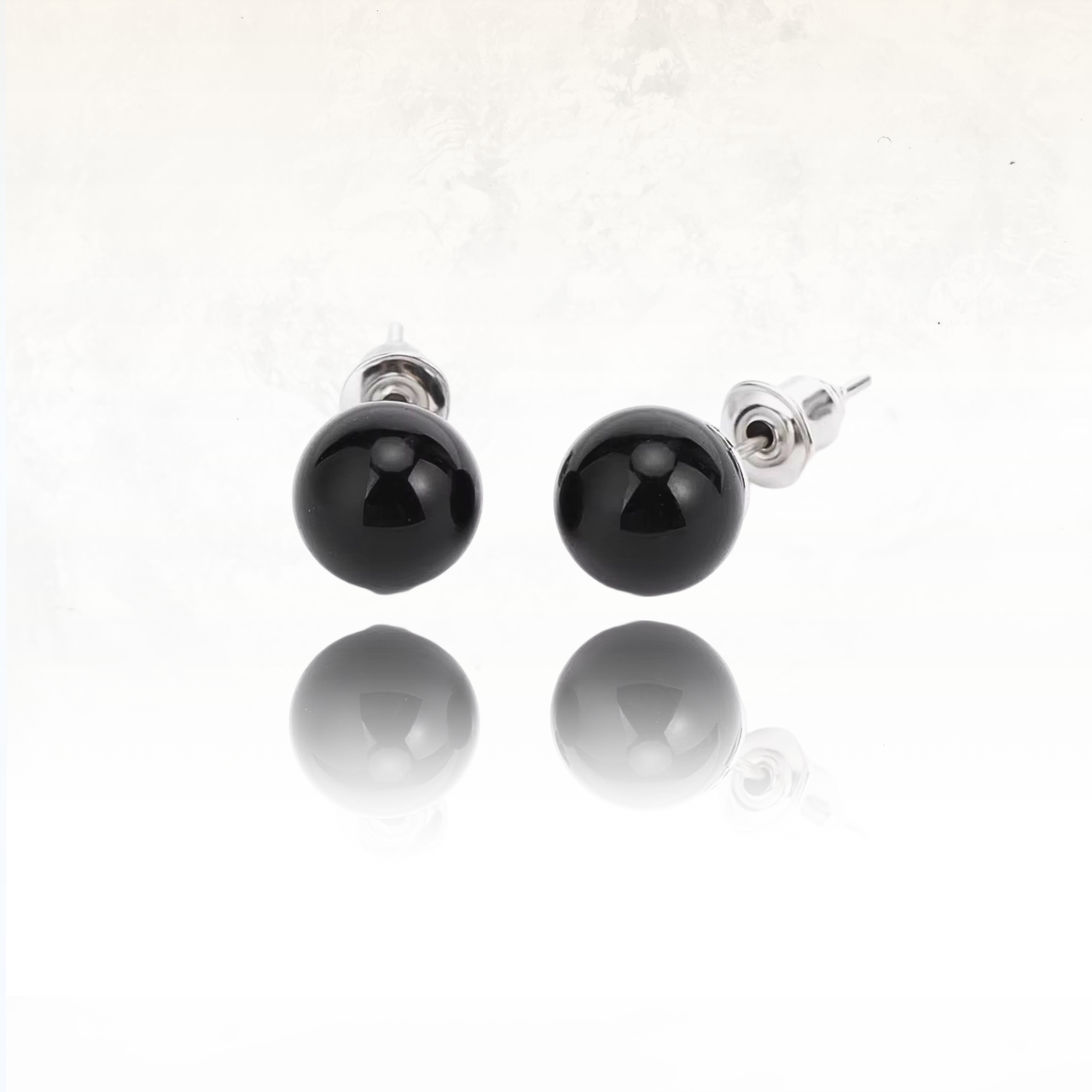 Clous d’oreilles en obsidienne polie, une touche d’élégance organique.